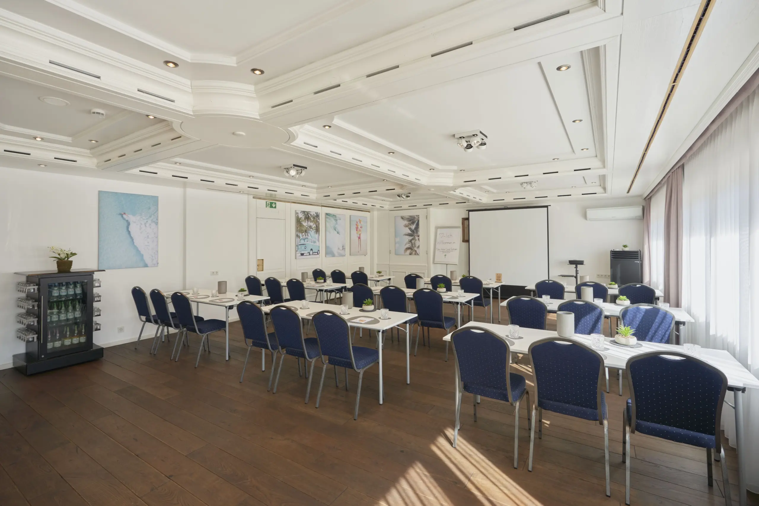 Großer, eleganter Saal mit Reihenbestuhlung und viel Tageslicht