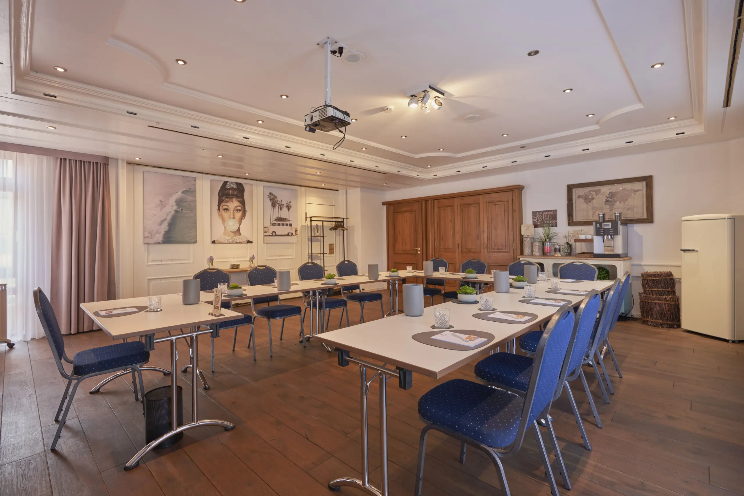 Konferenzraum mit Tischen in Blockform und blauen Stühlen